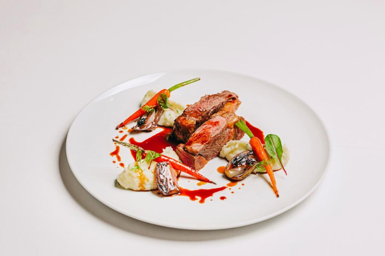 Ap Lago Montargil - Conference & Spa المظهر الخارجي الصورة The photo features a beautifully plated dish. At the center, there are slices of a tender meat, likely beef, showcasing a juicy pink interior. Accompanying the meat are several elements: vibrant orange carrots, perhaps roasted or glazed, and dollops 