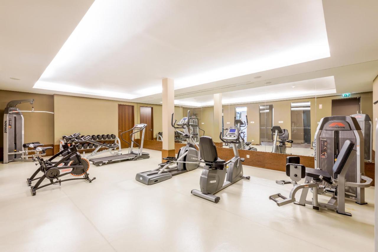 Ap Lago Montargil - Conference & Spa المظهر الخارجي الصورة The image shows a modern gym interior featuring various exercise equipment. On the left, there are free weights and weight benches. In the center, there are multiple machines, including a stationary bike and an elliptical. The space is well-lit with 