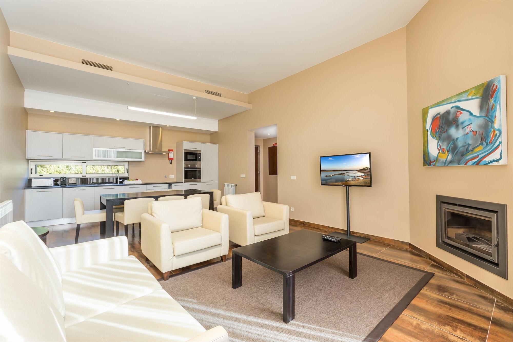 Ap Lago Montargil - Conference & Spa المظهر الخارجي الصورة The photo shows a modern, spacious living area with a contemporary design. The room features light-colored walls and wooden flooring. 

In the center, there is a black coffee table surrounded by four white armchairs. A flat-screen TV is mounted on th